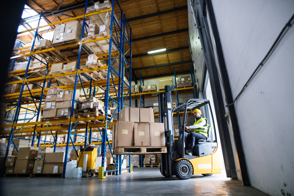 Man forklift driver working in a warehouse.