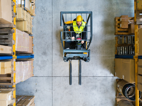 Man forklift driver working in a warehouse. Aerial view.