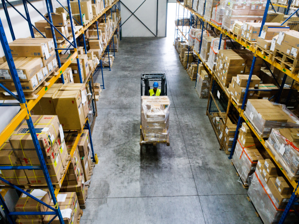 Man forklift driver working in a warehouse. High angle view.