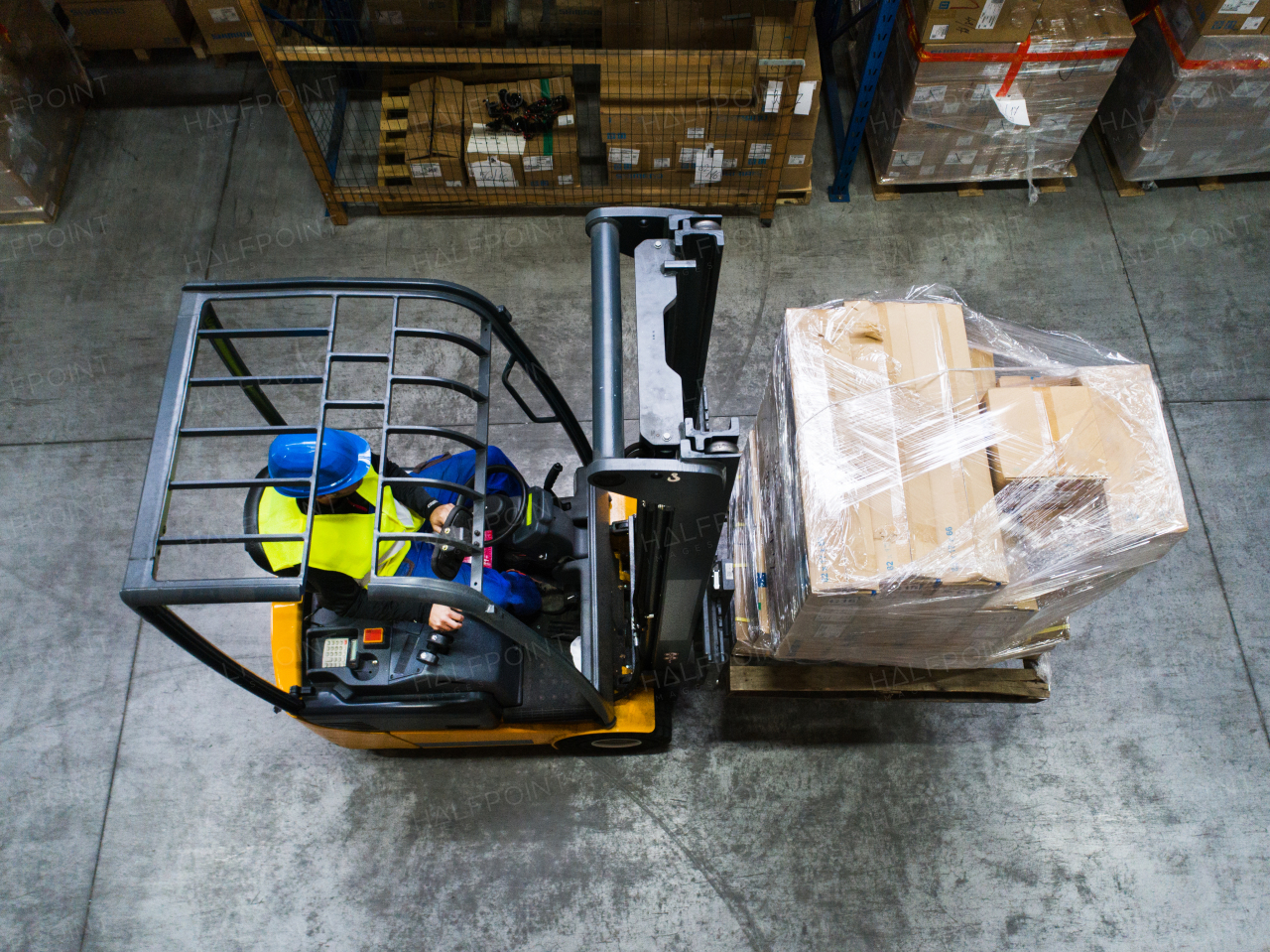 Man forklift driver working in a warehouse. Top view.