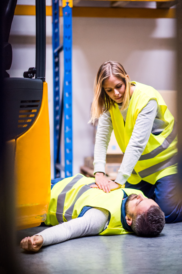 An accident in a warehouse. Woman performing cardiopulmonary resuscitation.