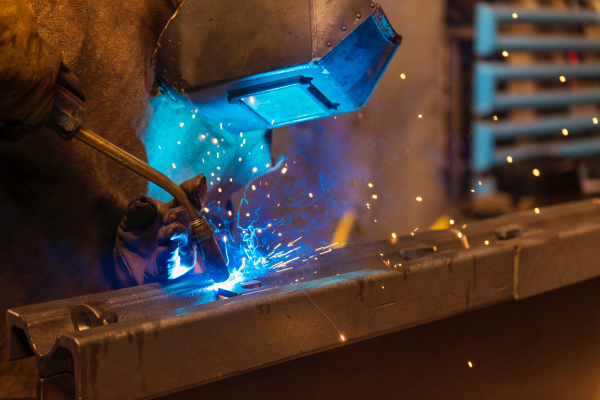 Young beautiful welder in the factory, hard working.