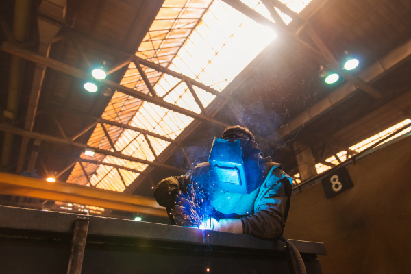 Young beautiful welder in the factory, hard working.