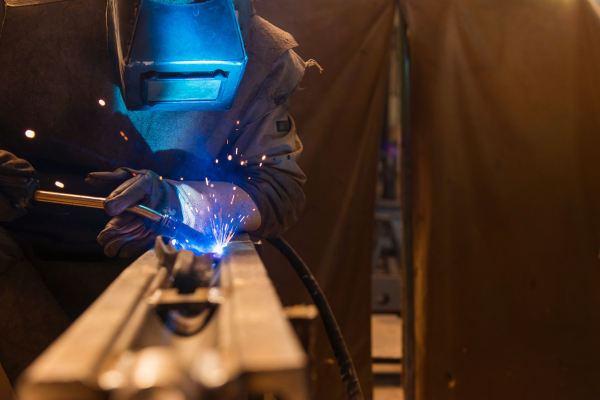 Young beautiful welder in the factory, hard working.