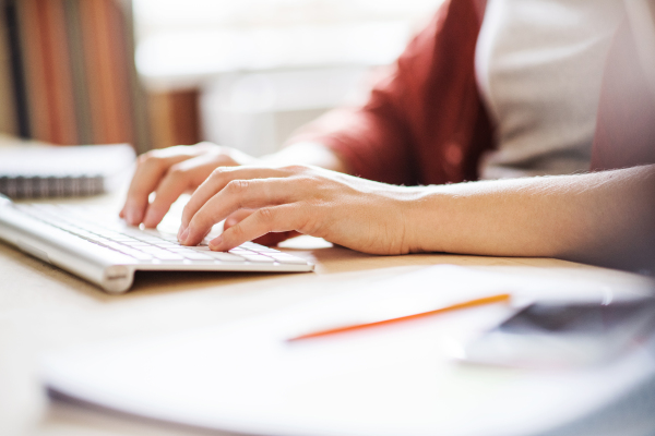 Unrecognizable businesswoman sitting at the desk, working.