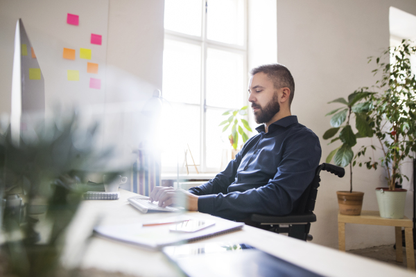 Businessman in wheelchair working in the office.