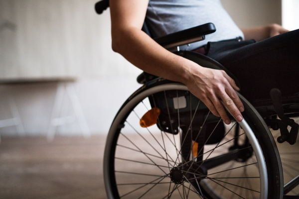 Unrecognizable man in wheelchair at home or in an office.