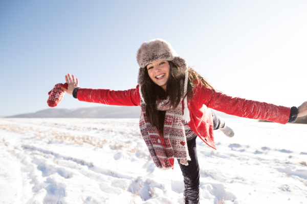 Beautiful young woman, having fun in the snow. Sunny white winter nature.