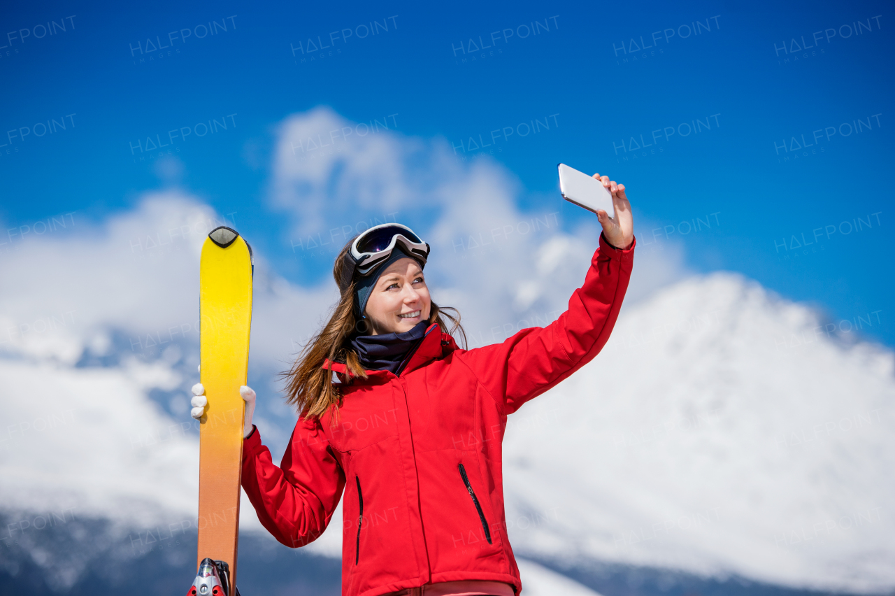 Young woman skiing outside in sunny winter mountains