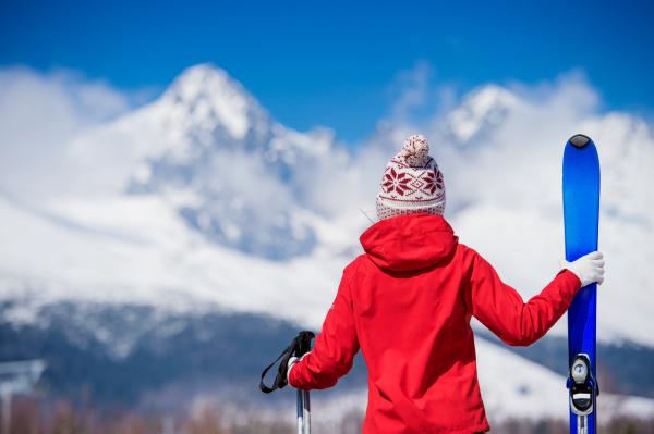 Young woman skiing outside in sunny winter mountains