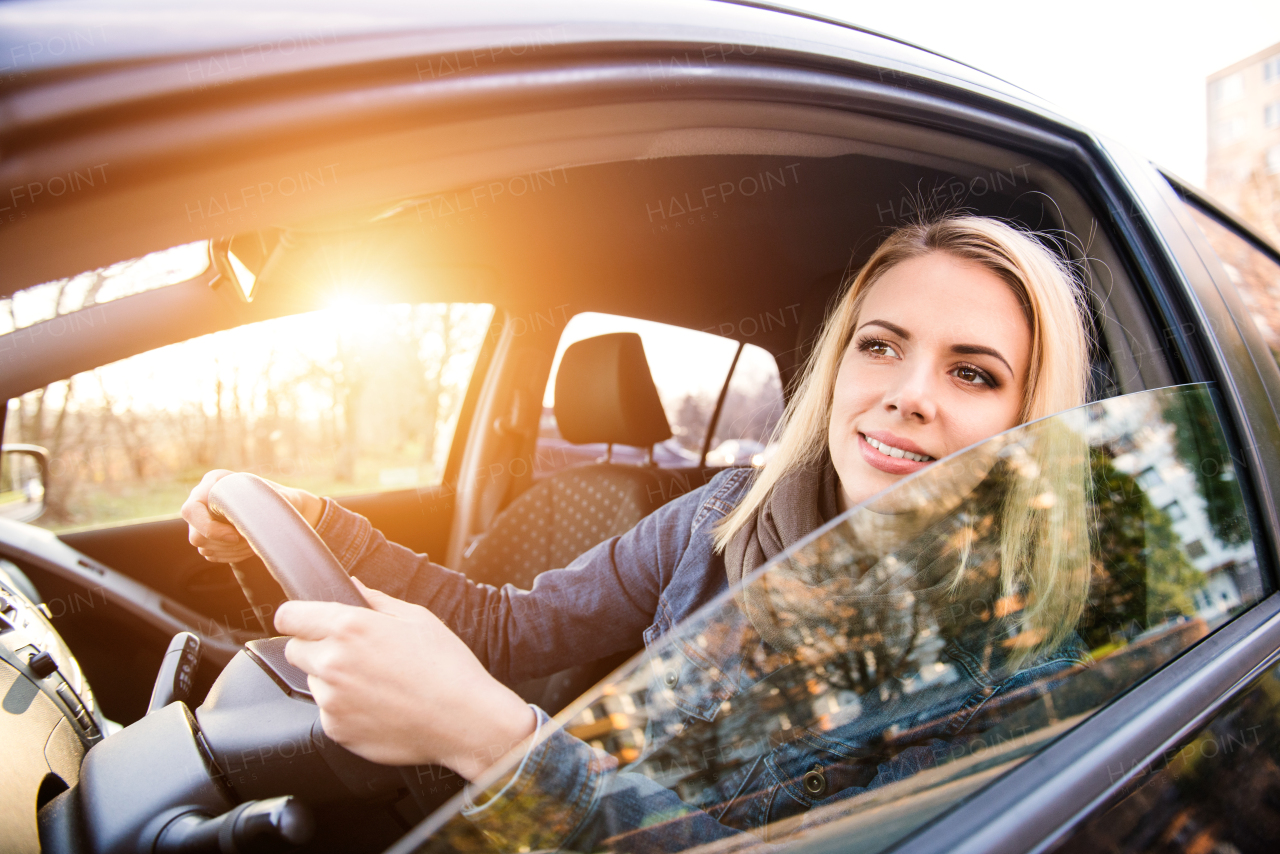 Beautiful young blond woman driving a car