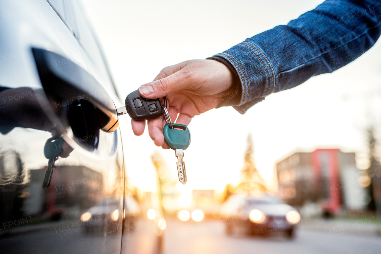 Unrecognizable woman opening her car with a key