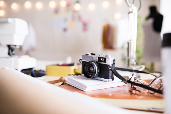 A camera on the table in interior of a modern studio. Designers startup business.