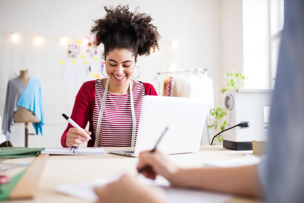 Young creative women with laptop working in a studio, startup business.