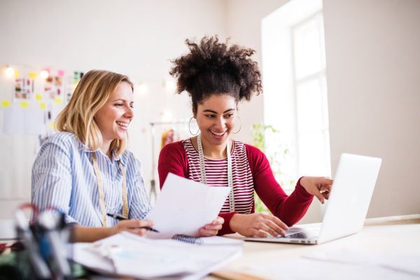 Young creative women with laptop working in a studio, startup business.