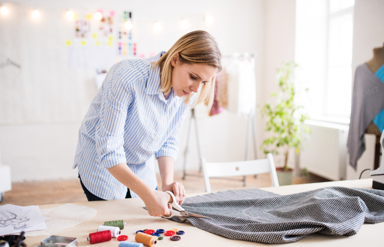 Beautiful young creative woman working in a studio, startup business.