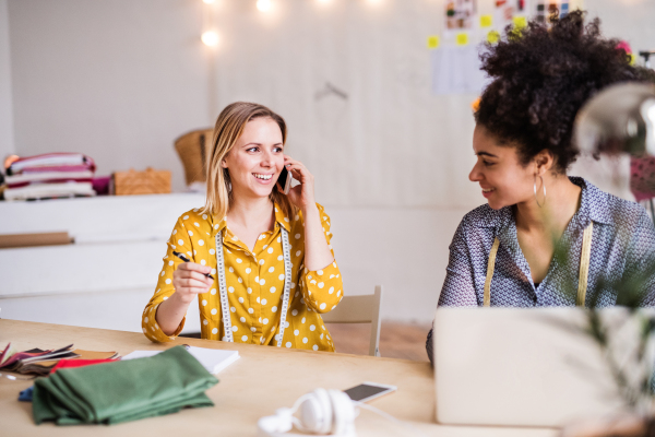 Young creative women with laptop and smartphone working in a studio, startup business.