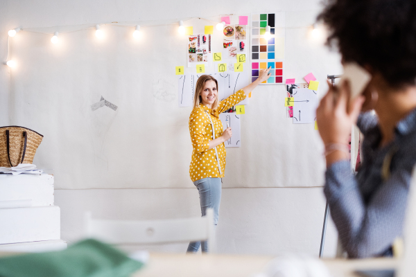 Young creative women with smartphone working in a studio, startup business.