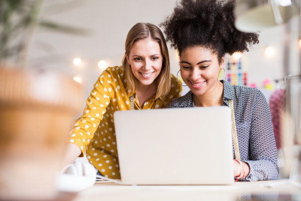 Young creative women with laptop and smartphone working in a studio, startup business.