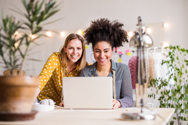 Portrait of young creative women with laptop working in a studio, startup business.