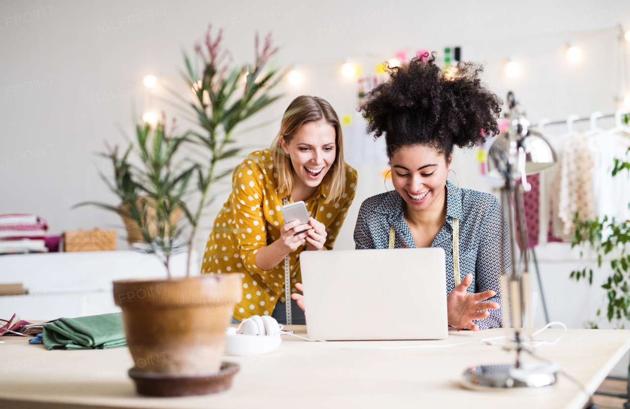 Young creative women with laptop and smartphone working in a studio, startup business.