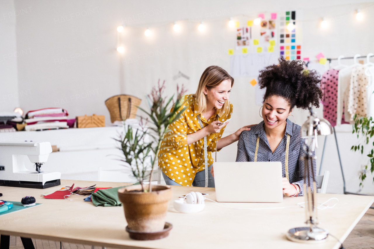 Young creative women with laptop and smartphone working in a studio, startup business.