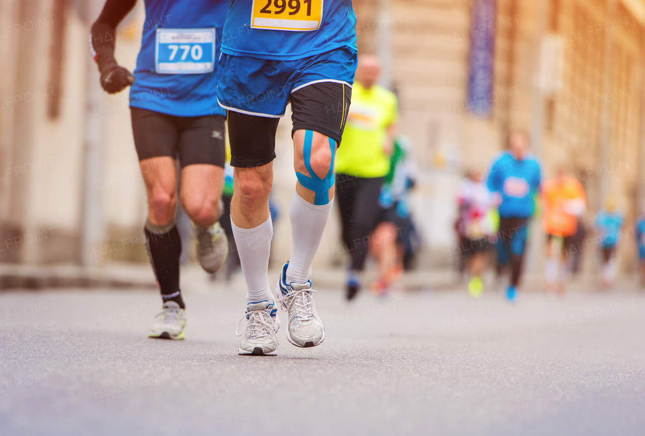 Young active runner during the marathon, in the city.