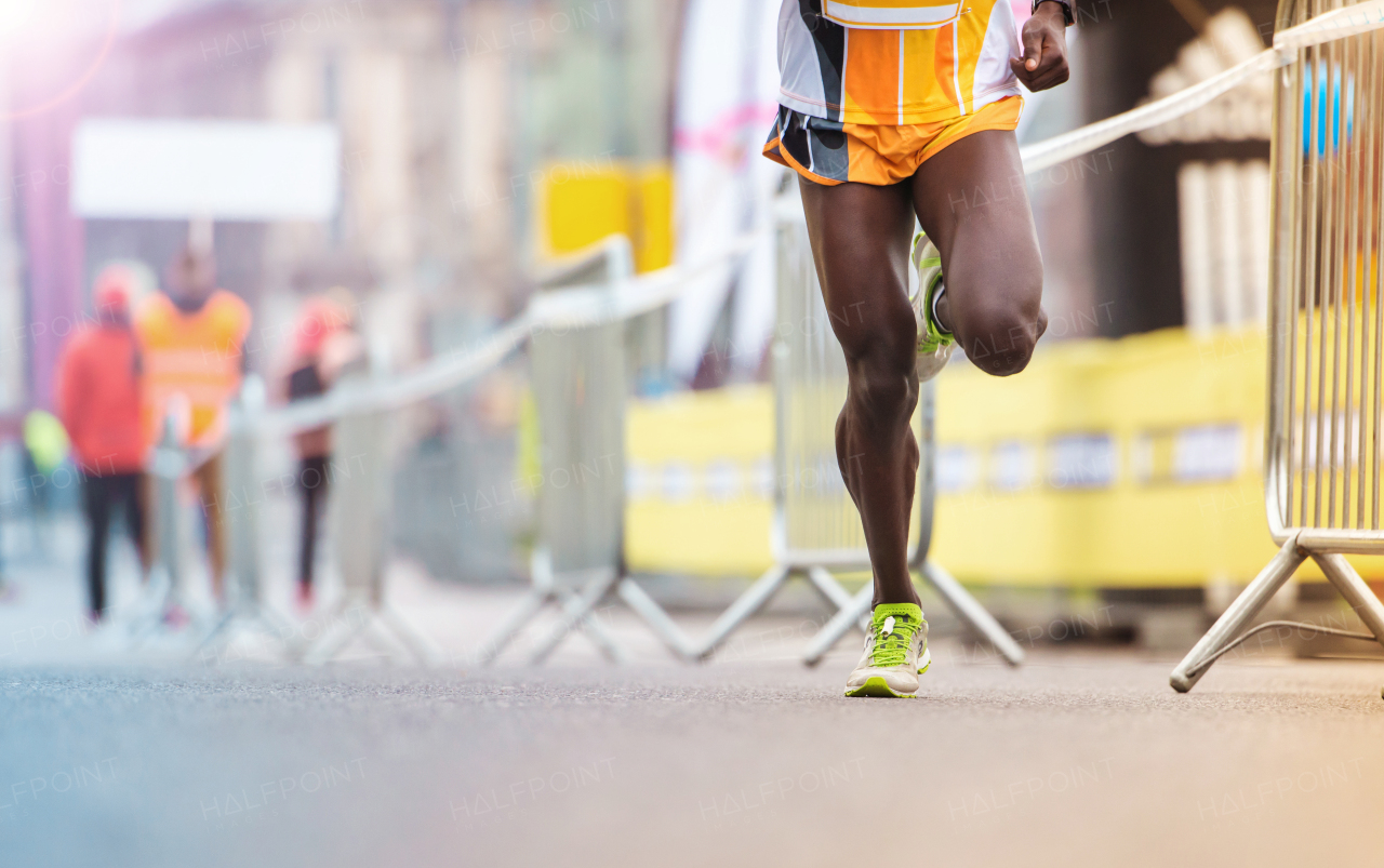 Young active runner during the marathon, in the city.