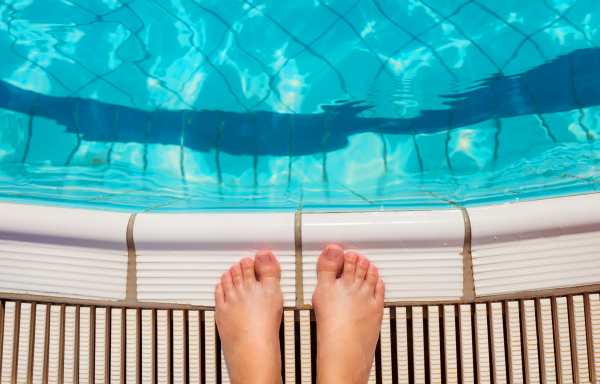 Young beautiful couple at swimming pool, summer time.