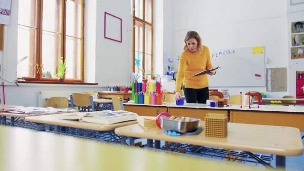 A young woman teacher in the classroom at school. Elementary school.