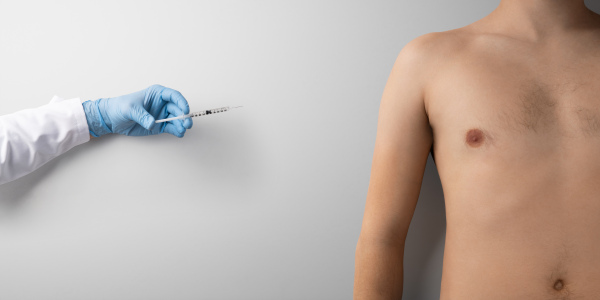 Hand with syringe injection and topless mans torso, covid-19 and vaccination concept. Copy space.