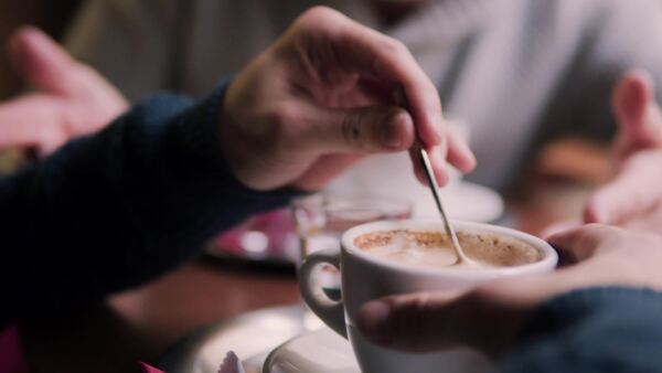 Senior father and his young son drinking coffee in a cafe.