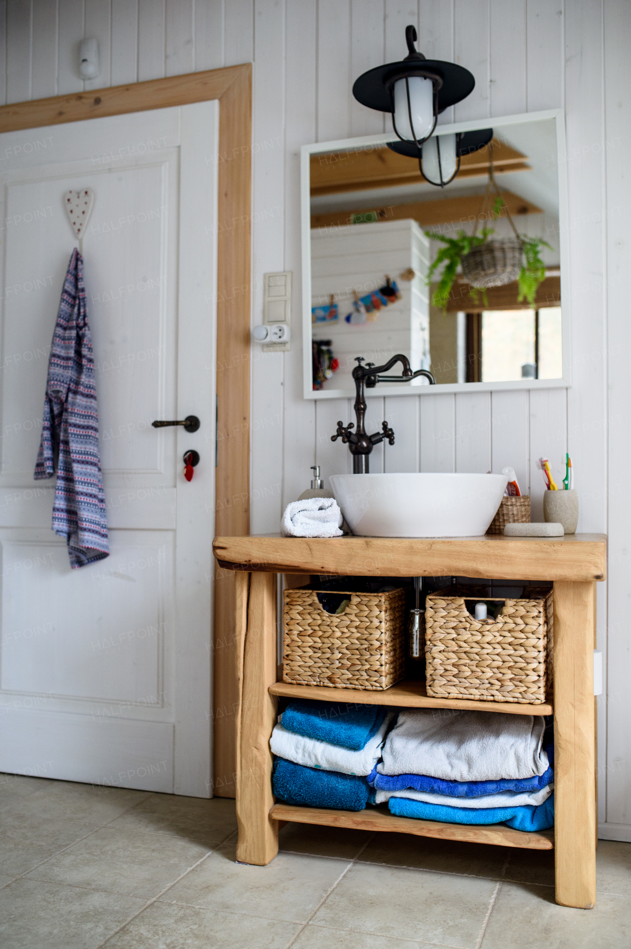 Sink, mirror and wooden cupboard in vintage bathroom at home.