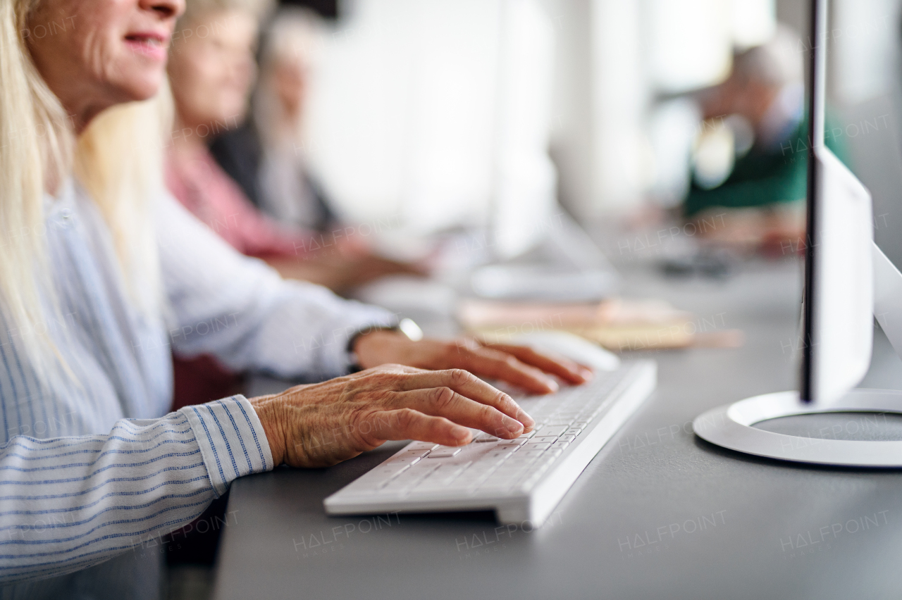 Group of unrecognizable senior people attending computer and technology education class, midsection.