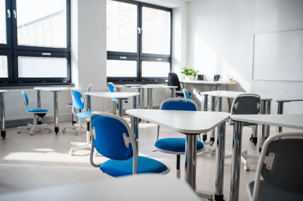 Desks, chairs and whiteboard in empty classroom. Copy space.