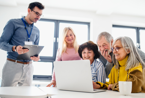 Group of cheerful senior people attending computer and technology education class.