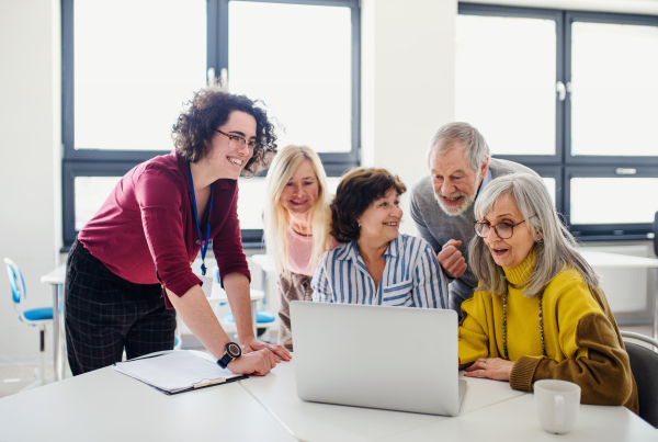 Group of cheerful senior people attending computer and technology education class.