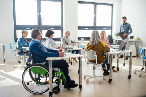 Group of cheerful senior people attending computer and technology education class.