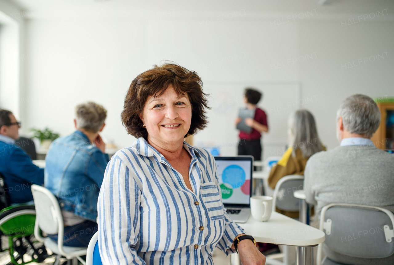 Portrait of senior attending computer and technology education class, looking at camera.