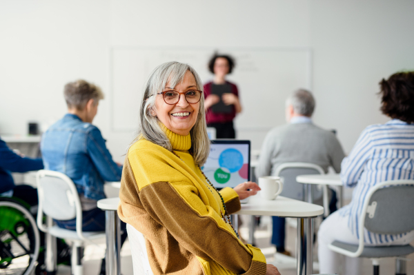 Portrait of senior attending computer and technology education class, looking at camera.