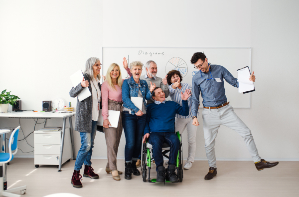 Group of cheerful senior people attending computer and technology education class.