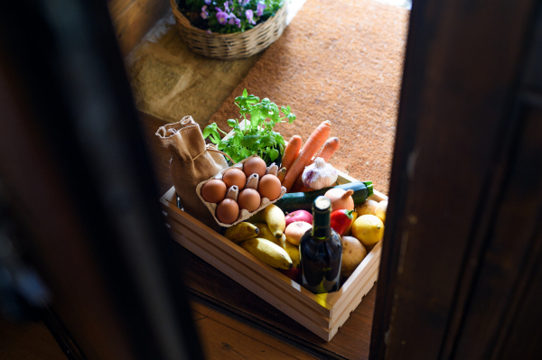 Top view of wooden box with food shopping at the doorstep, corona virus and quarantine concept.