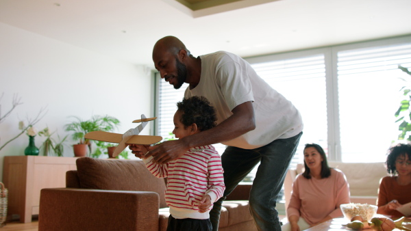 A multiracial father playing with his little son at home