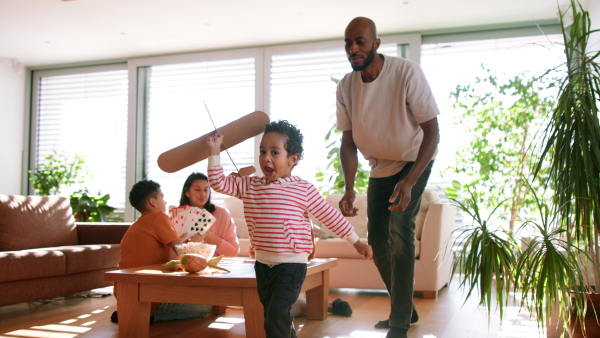 A multiracial father playing with his little son at home