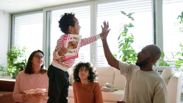 A happy multiethnic family enjoying time together at home, playing cards.