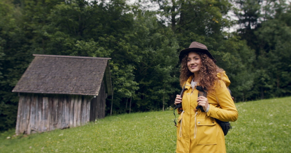 Happy young woman tourist with a backpack on a hiking trip in nature, walking.