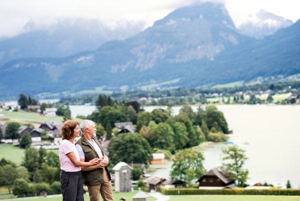 A senior pensioner couple hikers standing in nature, resting. Copy space.