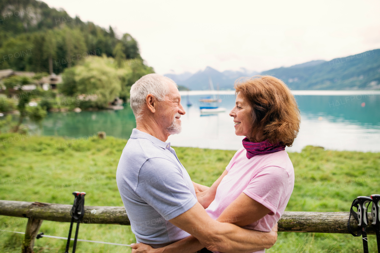 A happy senior pensioner couple hikers in love standing in nature, resting.