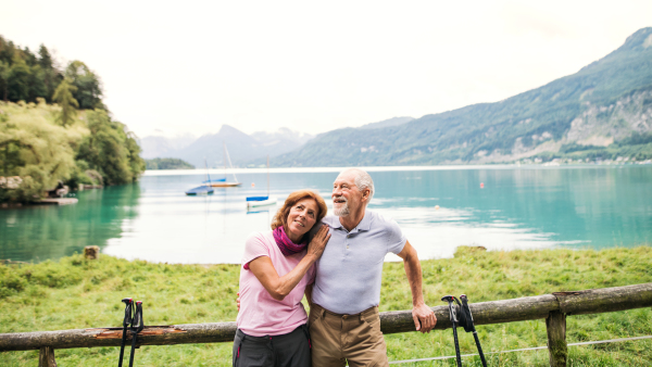 A senior pensioner couple hikers standing in nature, resting. Copy space.