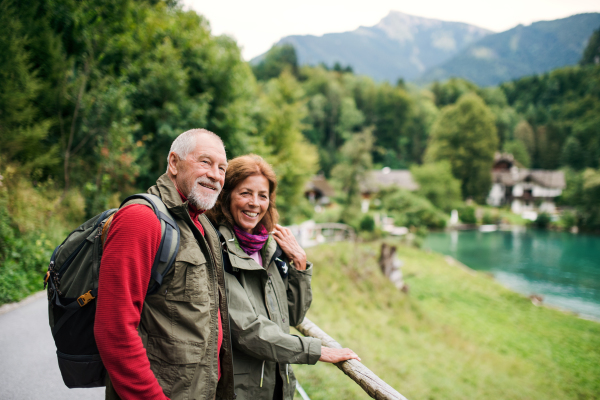 An active senior pensioner couple hiking in nature, resting. Copy space.